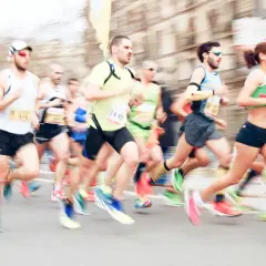 Course de marathon avec des coureurs en mouvement, certains portant des dossards.