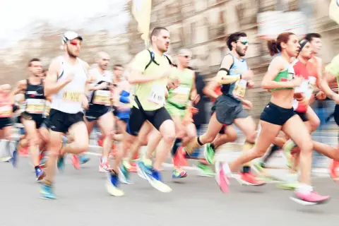 Course de marathon avec des coureurs en mouvement, certains portant des dossards.