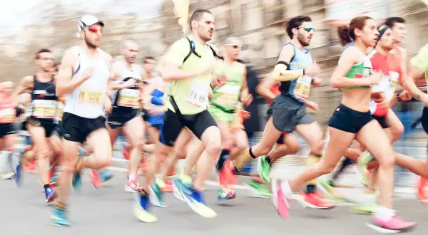 Course de marathon avec des coureurs en mouvement, certains portant des dossards.