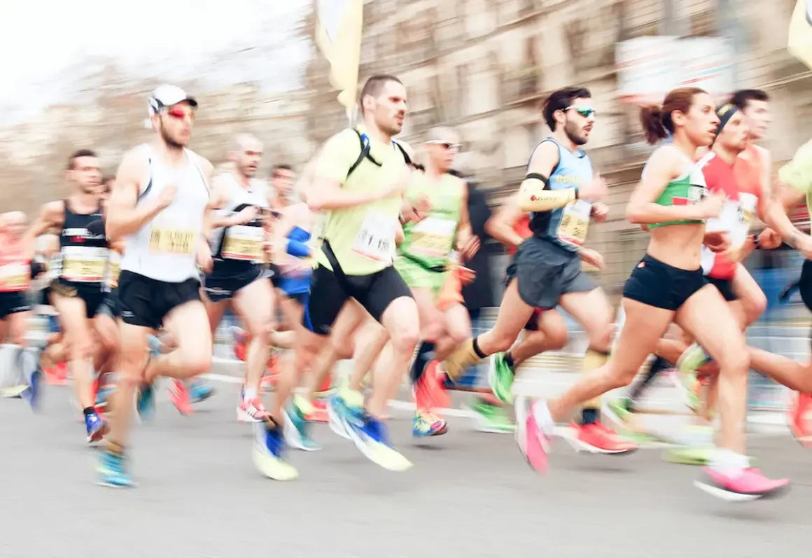 Course de marathon avec des coureurs en mouvement, certains portant des dossards.